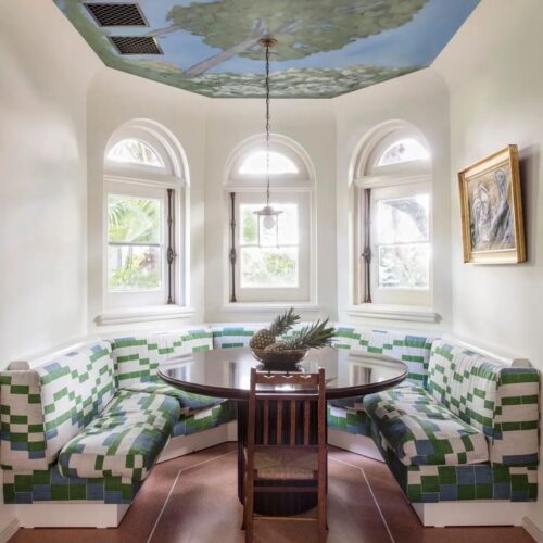 a delightful kitchen with beautiful banquette and a hand painted ceiling by the California-based artist Lukas Geronimas.