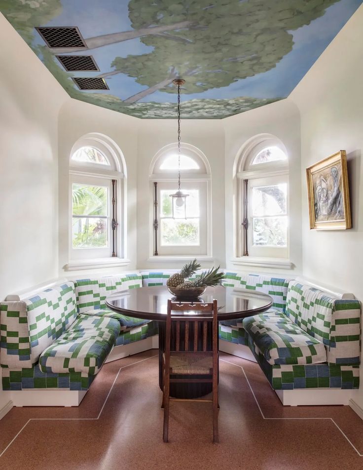 a delightful kitchen with beautiful banquette and a hand painted ceiling by the California-based artist Lukas Geronimas.