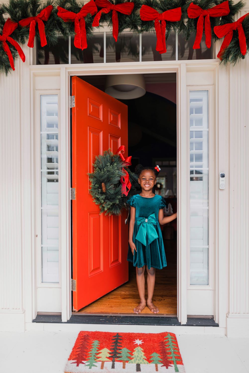 front door decorated for christmas with red bows