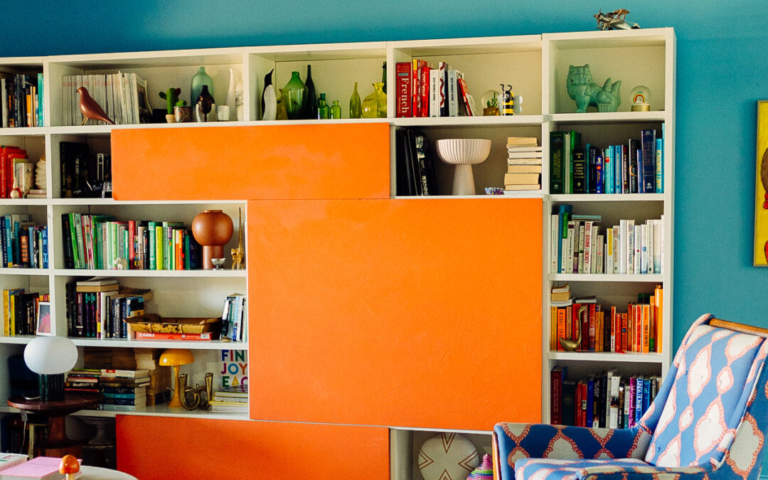 Italian bookcase and vintage pieces in color drenched living room