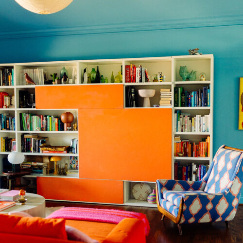 Italian bookcase and vintage pieces in color drenched living room