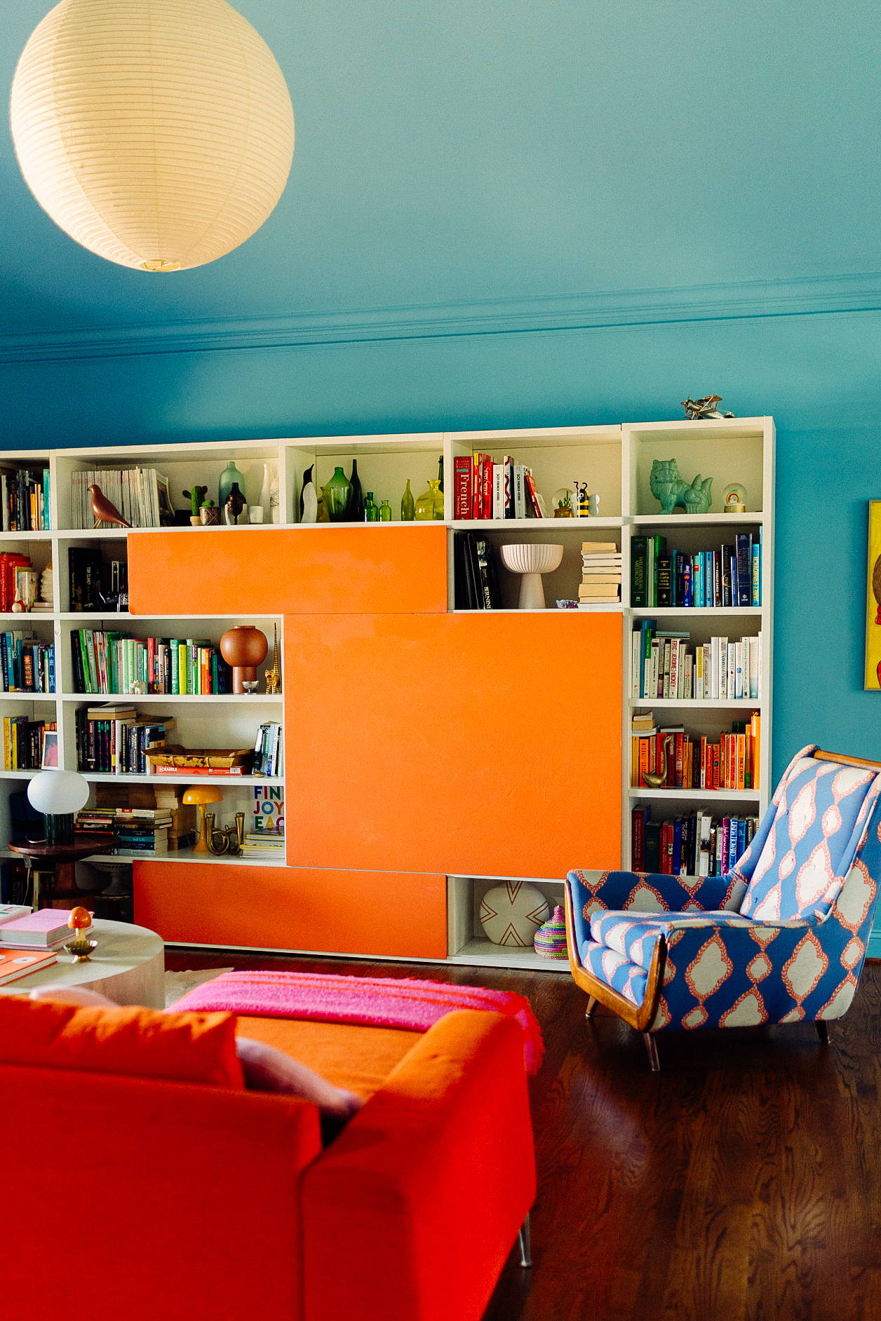 Italian bookcase and vintage pieces in color drenched living room