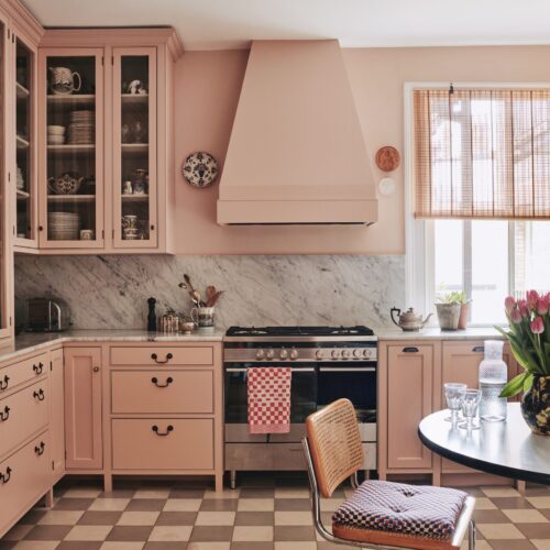 A beautifully designed pink kitchen with marble backsplash