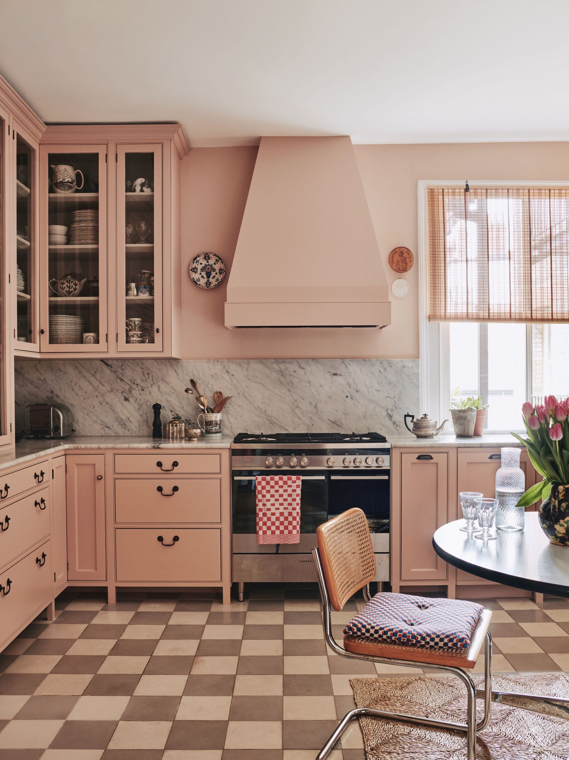 A beautifully designed pink kitchen with marble backsplash