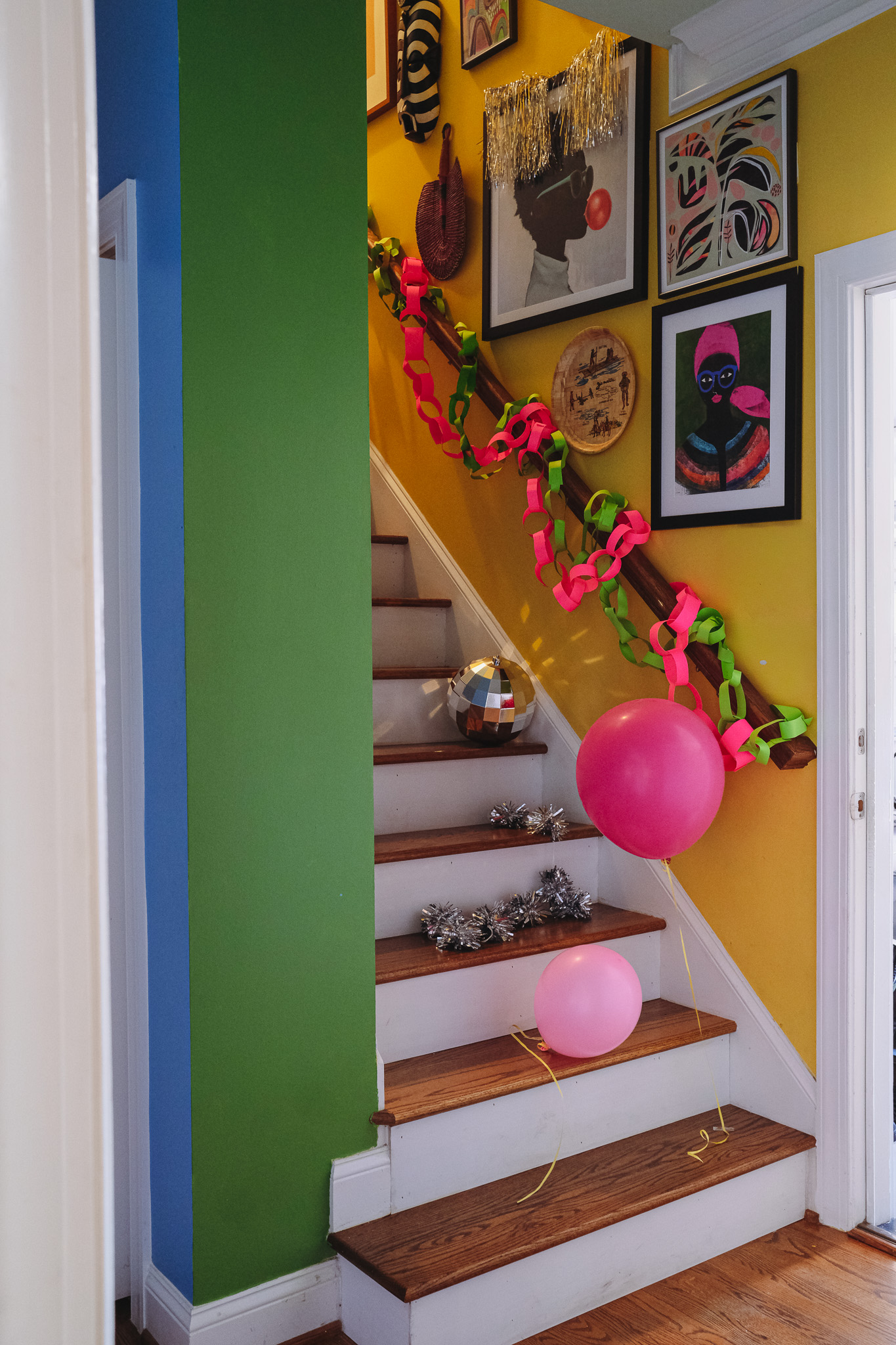 staircase with colorful christmas decorations, gallery wall, art