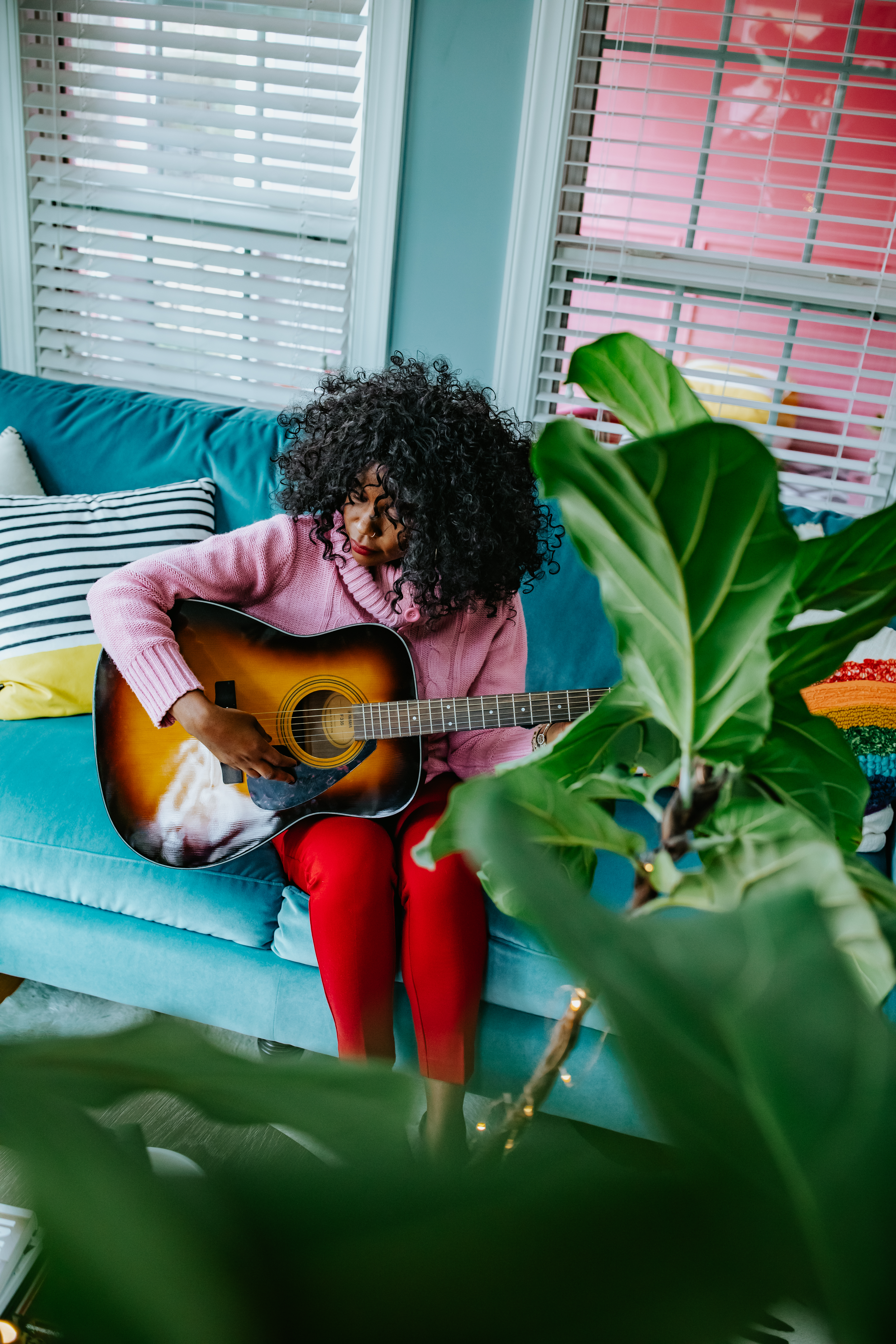 playing guitar in the sunroom with plants